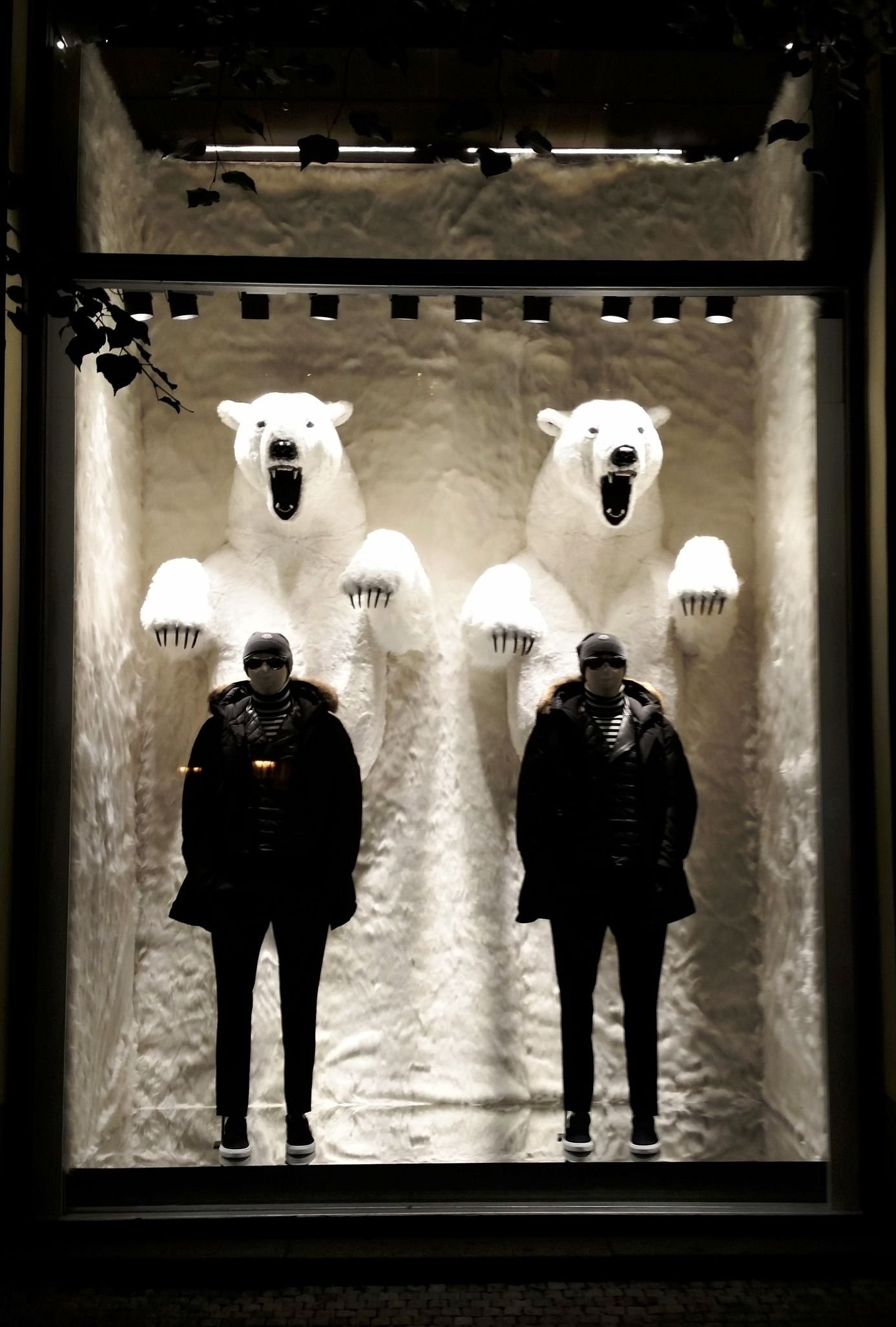 Beleuchteter Schaufensteraufbau mit zwei Eisbär-Figuren und zwei Schaufensterpuppen